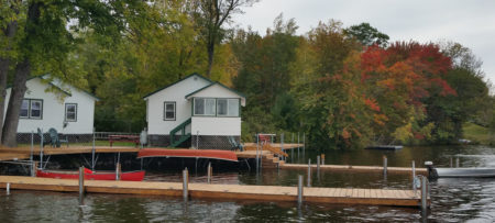 red and orange leaves show the start of fall behind cabins 1 and 2 with boat dock in front