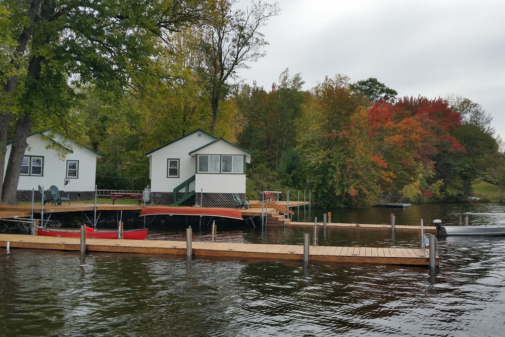 red and orange leaves show the start of fall behind cabins 1 and 2 with boat dock in front