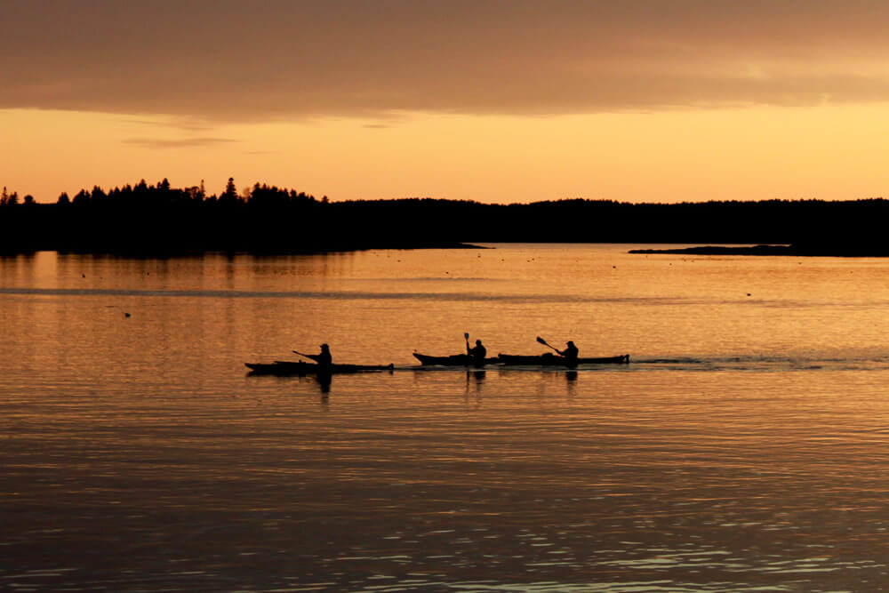 kayakers making their way across the pond as daylight fades